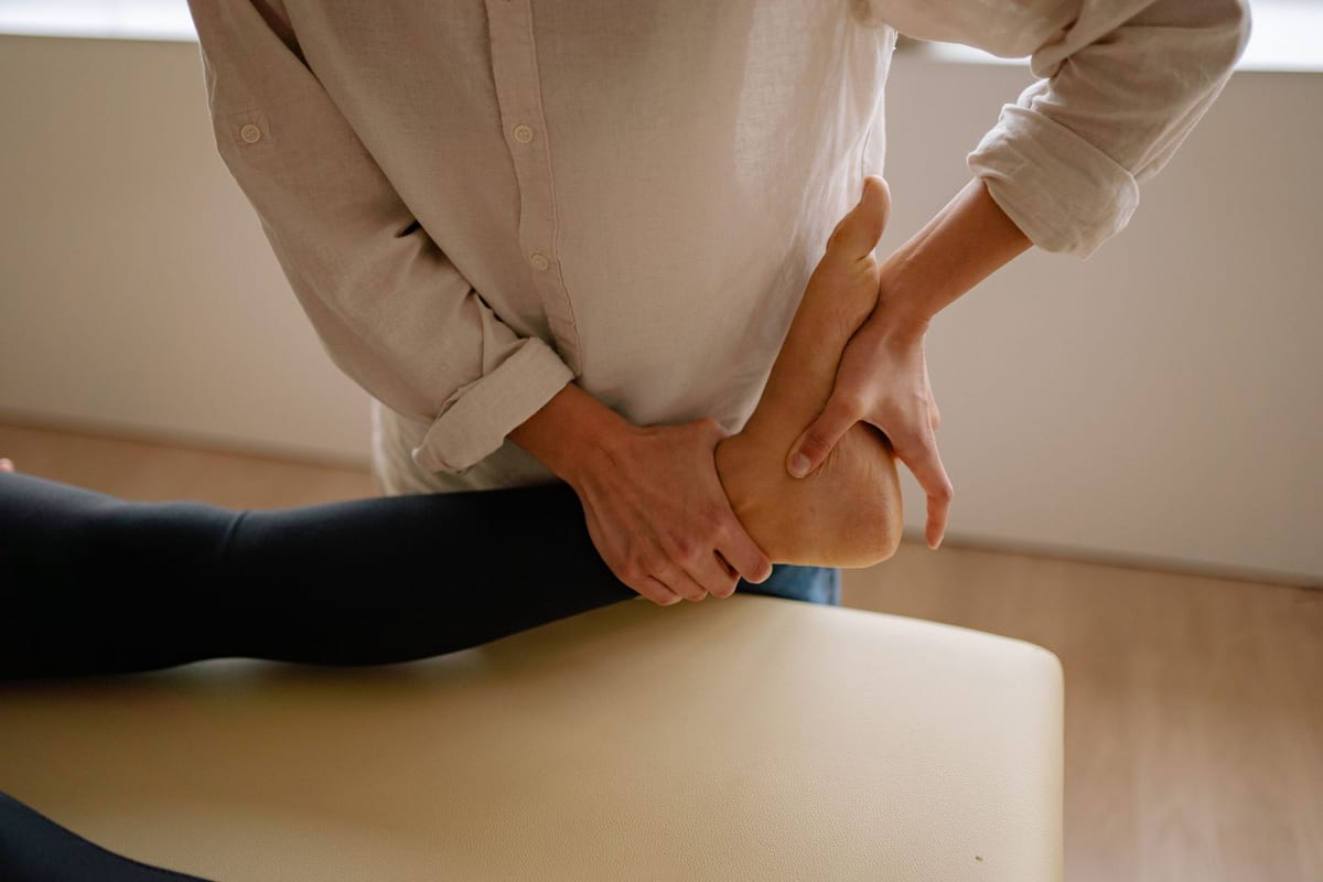 A therapist mobilising a patient's ankle during a rehab session